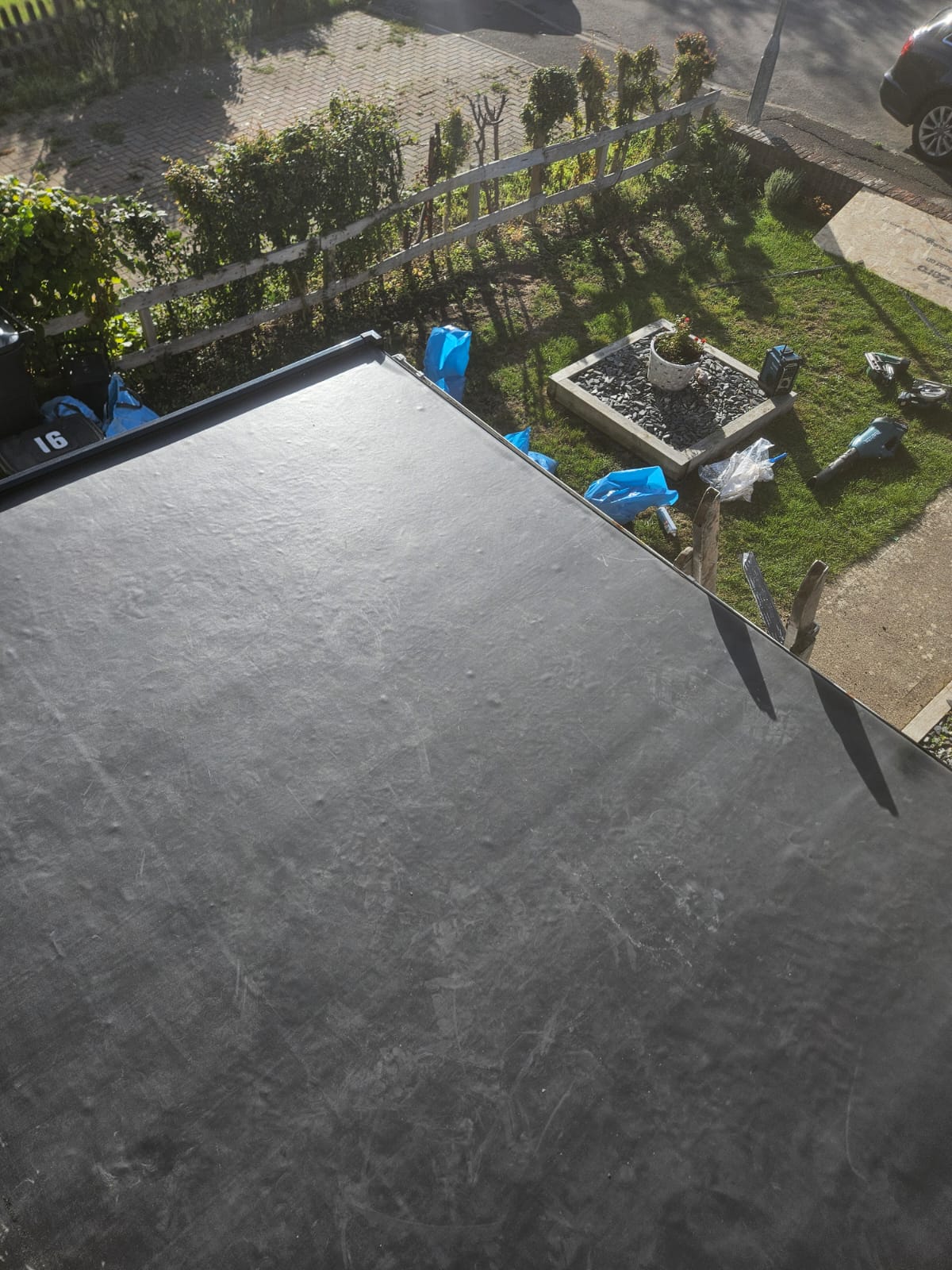 Completed EPDM flat roof on a rear extension beside a yellow rendered house wall