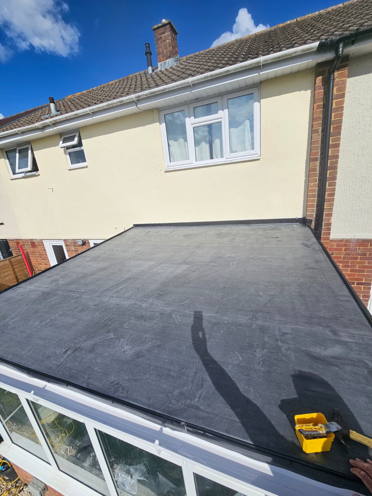 Large EPDM flat roof viewed across the membrane on a residential extension